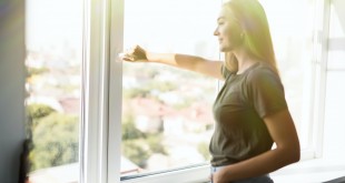 Happy woman open plastic windows for fresh air indoor