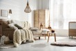 Cozy living room interior with beige sofa, knitted blanket and c