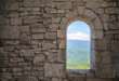 Stone war tower window with motion blurred bird and sea coast vi
