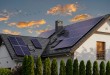 Modern house with blue solar panels on the roof. End of the day, sunset. Idyllic atmosphere.