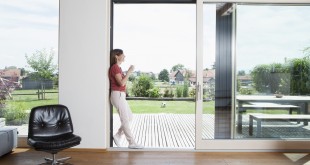 Mature couple leaning in garden door with cup of coffee