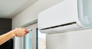 Hand adjusting temperature on air conditioner